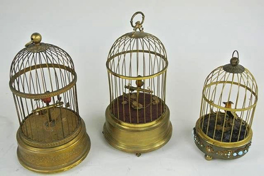 Three mechanical birdcages, tallest measures 10 inches. Estimate: $400-$500. Don Presley Auction image.