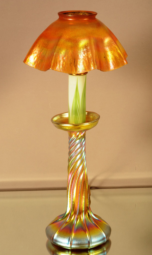 Tiffany Studios gold Favrile candlestick lamp, base signed L.C.T. Favrile, shade signed L.C.T., 16 inches high, circa 1910. Estimate: $1,400-$2,200. Bruhns Auction Gallery image.