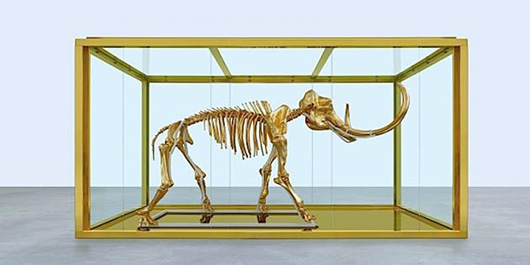 A gilded skeleton of a woolly mammoth in a steel and glass vitrine, created and donated by British artist Damien Hirst, was purchased by a Russian billionaire in the amfAR auction for 11 million euros (US$14.99 million). Copyright Damien Hirst and Science Ltd. All rights reserved, DACS 2014. Image used by permission of the artist.