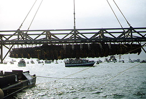 The Confederate submarine H.L. Hunley, suspended from a crane during her recovery from Charleston Harbor on Aug. 8, 2000. Image by Barbara Voulgaris, Naval Historical Center, courtesy of Wikimedia Commons.