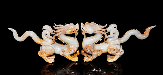 Lot 289, an unusual pair of Song Dynasty white jade dragons driven by fairies and captured mid-flight. Each has a medallion on its shoulder and haunch. Of translucent jade with opaque buff inclusions, the pair is 3 1/2 inches high by 7 inches long. The estimate is $80,000-$100,000. Gianguan Auctions image.