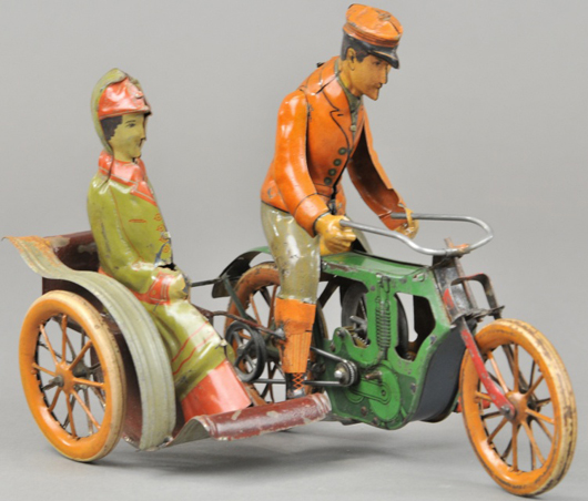 M & K tinplate clockwork motorcycle with sidecar and woman passenger, sold for $10,620. Bertoia Auctions image