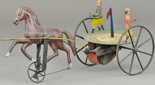 Painted tinplate with cast-iron revolving horse clockwork toy with American Flag, sold for $8,850. Bertoia Auctions image