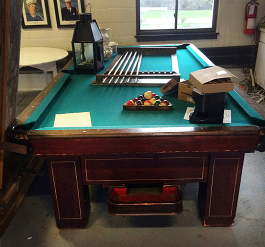 Vintage Brunswick-Balke-Collender Co. slate-top mahogany pool table with beautiful cue rack. Tim’s Inc. Auctions image.