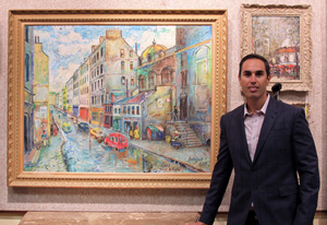 Auctioneer Russ Kodner standing beside the highlighted item of the auction, David Davidovich Burliuk’s ‘Paris Rue St. Rock,’ oil on canvas, which sold for $53,100. Kodner Galleries image.