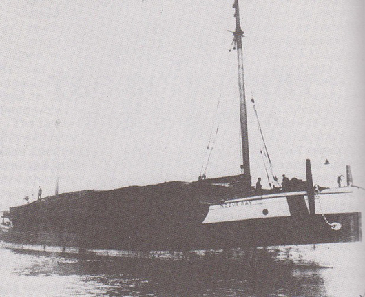 The Noquebay, shown loaded with lumber, was built in 1872 as a schooner but was eventually used as a barge. It caught fire off Stockton Island on Oct. 9, 1905. Image courtesy of Wikimedia Commons.