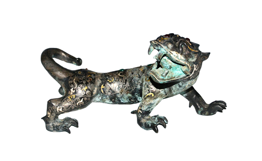 Lot 248, a gilt and silver-inlaid bronze and mythical beast cast with dragon head and tiger body inlaid with a pattern of cloud scrolls, geometric and beasts pattern and embellished with hardstone. Warring States period. Estimate: $80,000-$100,000. Gianguan Auctions image.