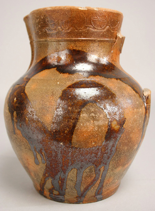 Although missing its handle, the redware pitcher clearly bears the stamp of C.A. Haun by the compass star on the upper rim; the lot brought $9,988 at Case in 2010. Image courtesy Case Antiques.