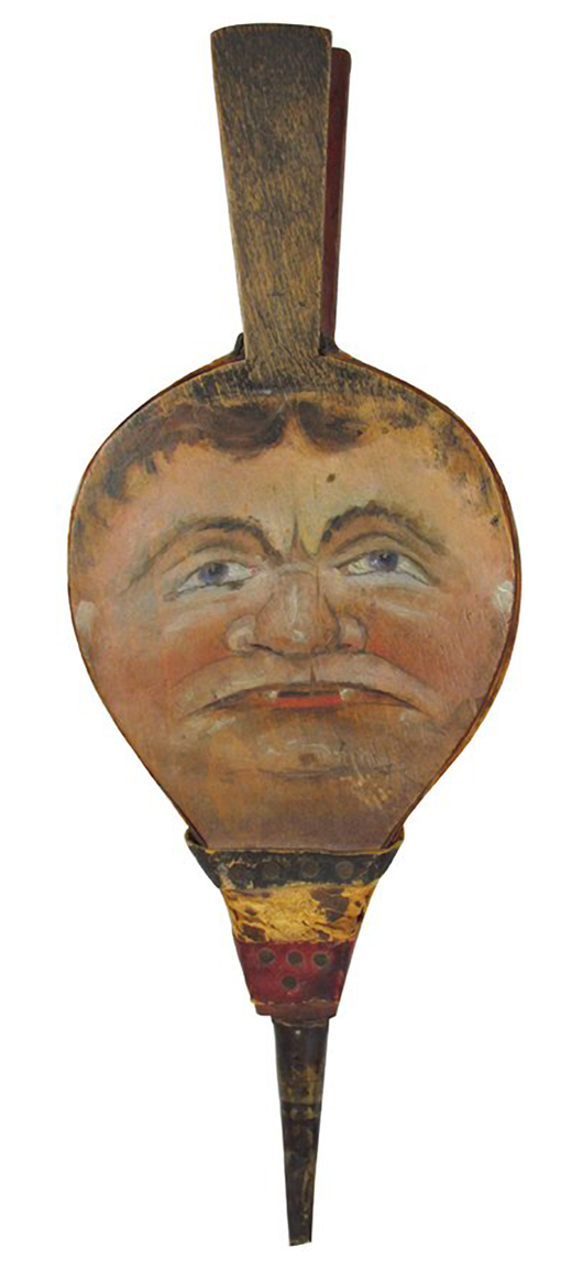 A man's face is a clever decoration on a bellows used to fan flames in a fireplace. The rare 19th-century bellows sold at auction for $2,700.