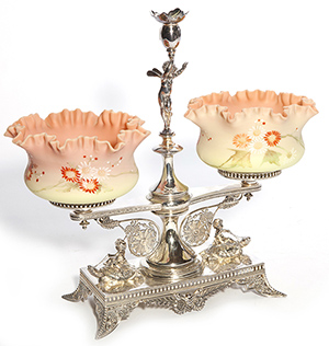 This 19-inch-high fruit stand, sometimes called a berry set, is made of silver-plated metal with Burmese glass bowls. It sold in the spring of 2014 at an Early's Art Glass auction in Milford, Ohio, for $3,220.