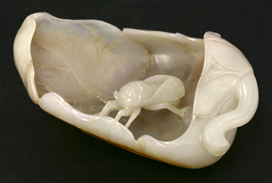 Amusing jade brush washer, 20th century, carved with a wasp on a curled lotus leaf, 9.8cm. Sworder image