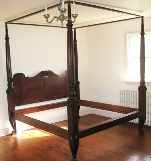 19th-century walnut tester bed with hairy paw feet, paneled headboard, reeded and carved bedposts, converted to king size. Est. $300-$600. Stephenson’s image