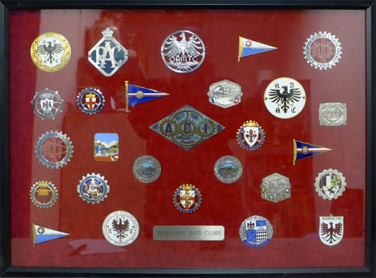 Collection of worldwide auto club enameled medals, emblems and medallions displayed under glass on red velvet. Clubs include Milano, De Nice et Cote d’Azur, Firenze, etc. Est. $2,000-$3,000. Sterling Associates image
