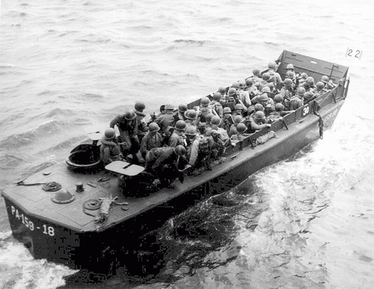 A Navy landing craft carrying Army troops, possibly as reinforcements at Okinawa in April 1945. US Navy photo, courtesy of Wikimedia Commons.