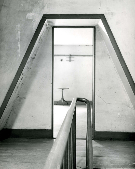 'Second Dwelling House,' view through door with railing, candle stand, and double clothes hanger (North Family, Mount Lebanon, New York)