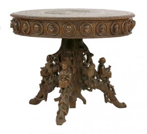 An extraordinary Black Forest carved walnut center table, the circular top carved in low relief with a central panel of chamois in a forest landscape within a border of fruiting vines and birds, 40.4in. diameter. Estimate: £3,000-£5,000. Sworders image.