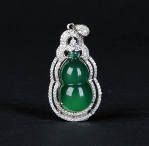 Highly translucent jadeite pendant, gourd-shaped, embedded in white gold setting with numerous diamond bezels. Length: 1.25in x width: 0.75in. Linwoods Auction image