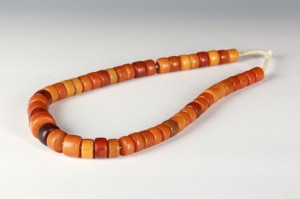 A strand of amber beads, comprised of button-like beads of yellow-orange caramel tone, naturally blended into. Length: 18.5in. Weight approximately 14.5 oz. Linwoods Auction image