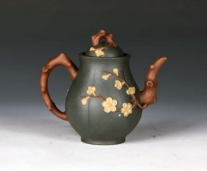 Ben Shan green zisha teapot in a pear shape, with exquisite plum relief on the pot body and plum tree knots on the spout and handle. Length: 5.25in x width: 3.25in x height: 5in. Linwoods Auction image