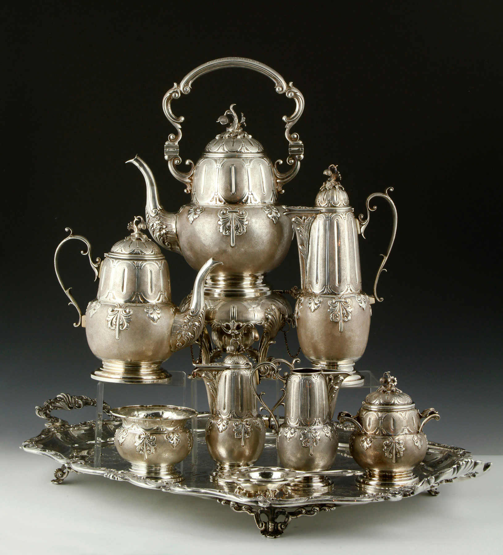 The Fornari Roma tea set lives up to its massive reputation, weighing approximately 407.6 troy ounces total weight. The sterling silver service includes a tray, water pitcher, chocolate pot, teapot and warmer, cup, sugar, covered creamer and tea strainer, all marked 'Fornari, Roma.' Kaminski Auctions images