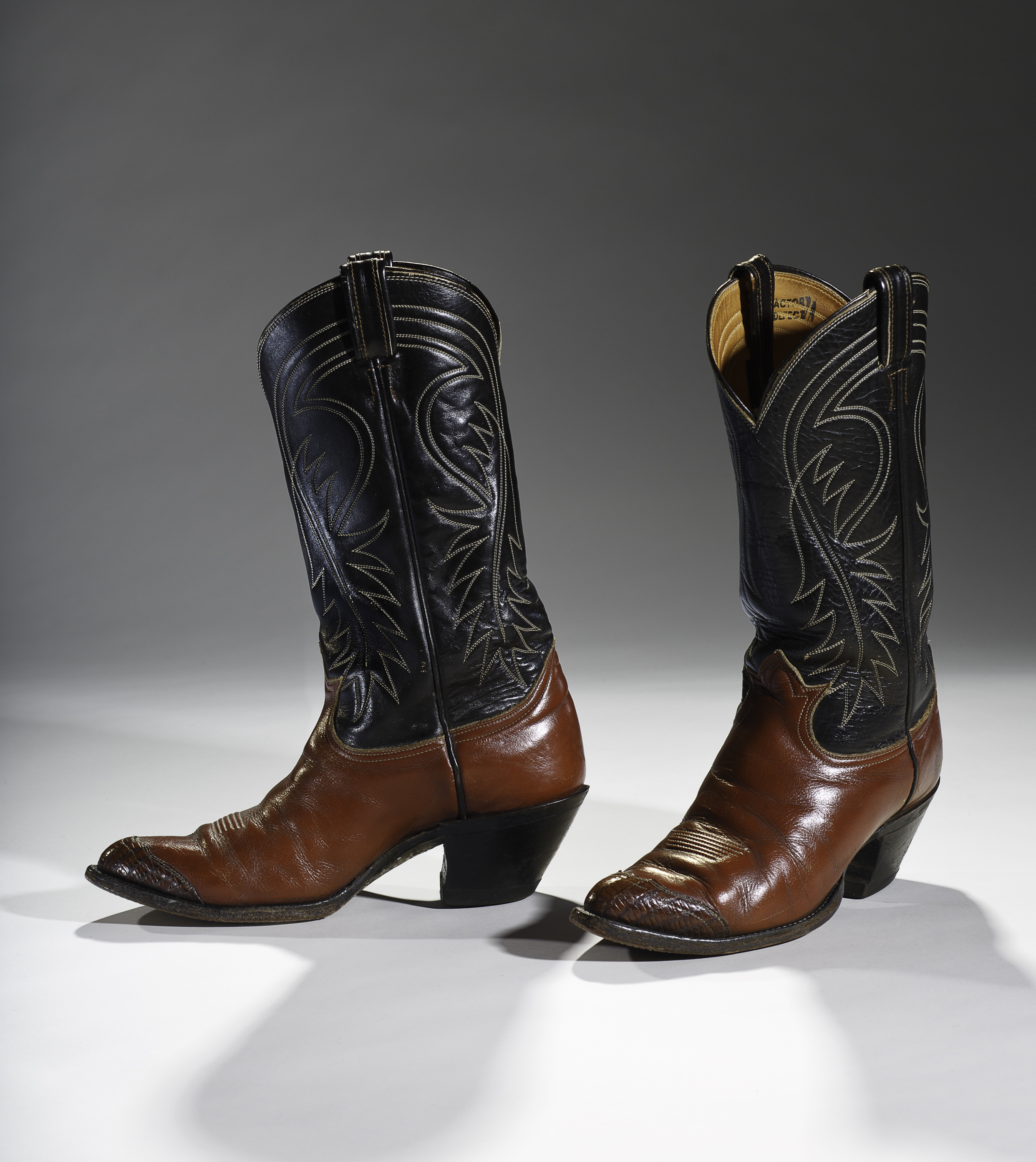 From dime novels and Wild West shows to Hollywood Westerns, the high-heeled cowboy symbolized unfettered freedoms and self-reliance in the 20th century. Although 19th century cowboys first splurged on ostentatious cowboy boots after reaching the railheads at the end of a long cattle drive, it took Hollywood and dude ranches for the cowboy boot with its pointy toe and low slung heel to finally take shape. This pair of Tony Lama boots reflects the fashion for finery from the use of lizard skin at the toe to the high-stacked leather heel. Collection of the Bata Shoe Museum. Photo credit: Image © 2015 Bata Shoe Museum, Toronto, Canada (photo: Ron Wood) 