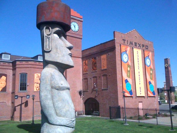 Timexpo, which will close in September, is located in the Brass Mill Commons shopping center. Its location is marked by a 40-foot-high replica of an Easter Island Moai statue, which connects with the museum's archaeology exhibit. Image by Dtgriffith. This file is licensed under the Creative Commons Attribution 3.0 Unported license.