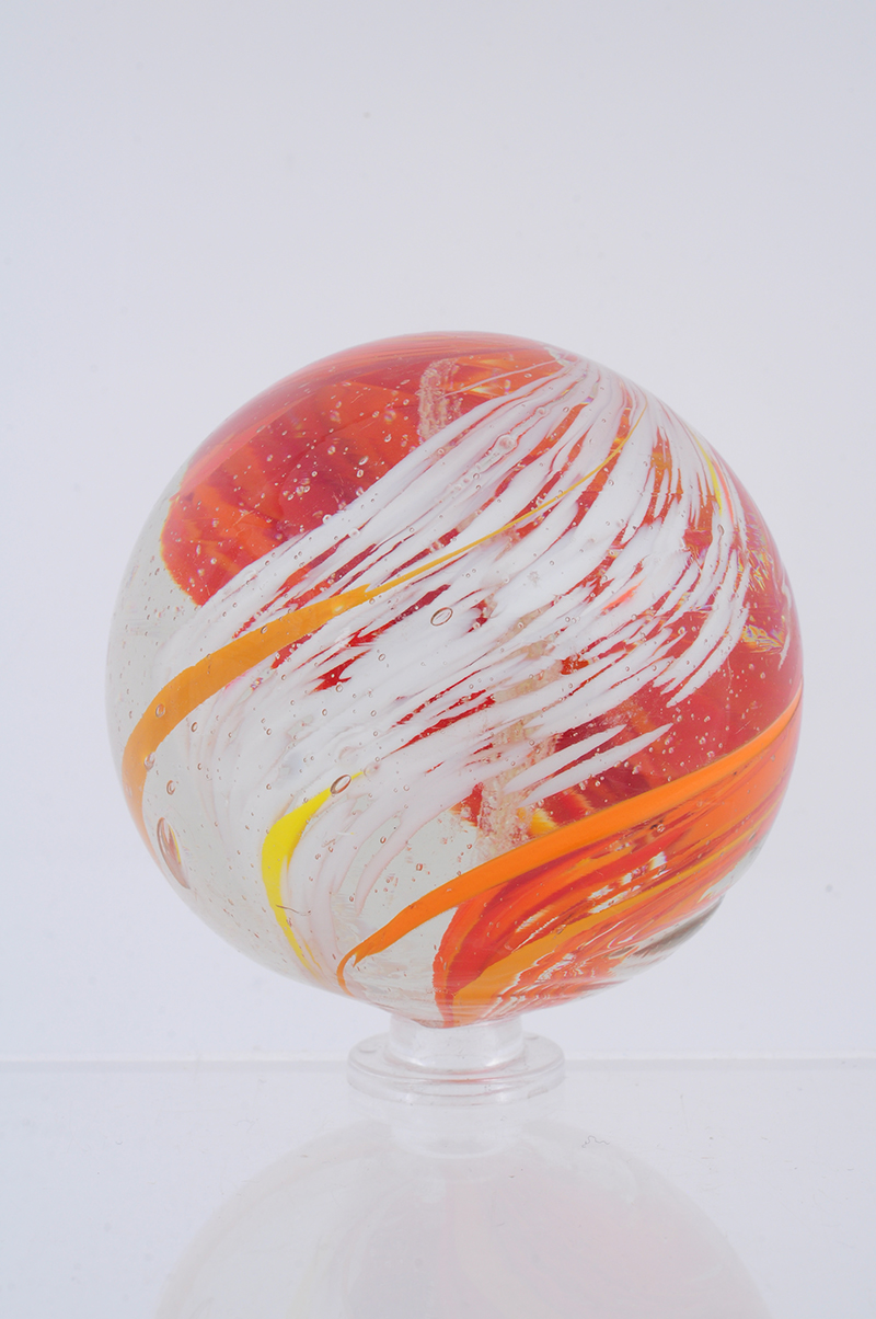 2-3/8 inch banded transparent marble with yellow and pumpkin orange swirls, $10,800. Morphy Auctions image