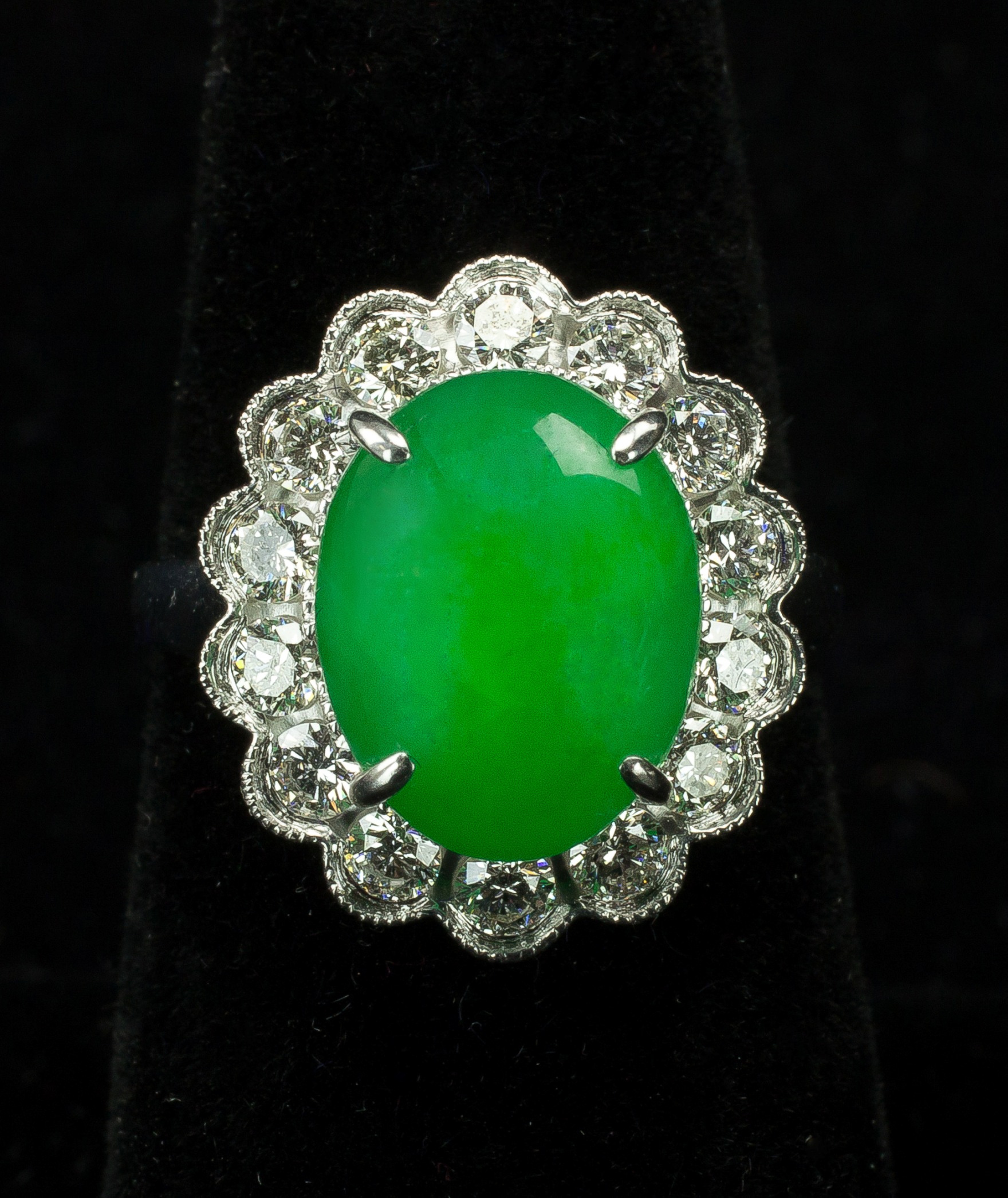 An 18K white gold ring with a vivid green jadeite jade cabochon and diamonds weighing approximately 1.2 carats sold for $5,400. Artingstall & Hind Auctioneers image
