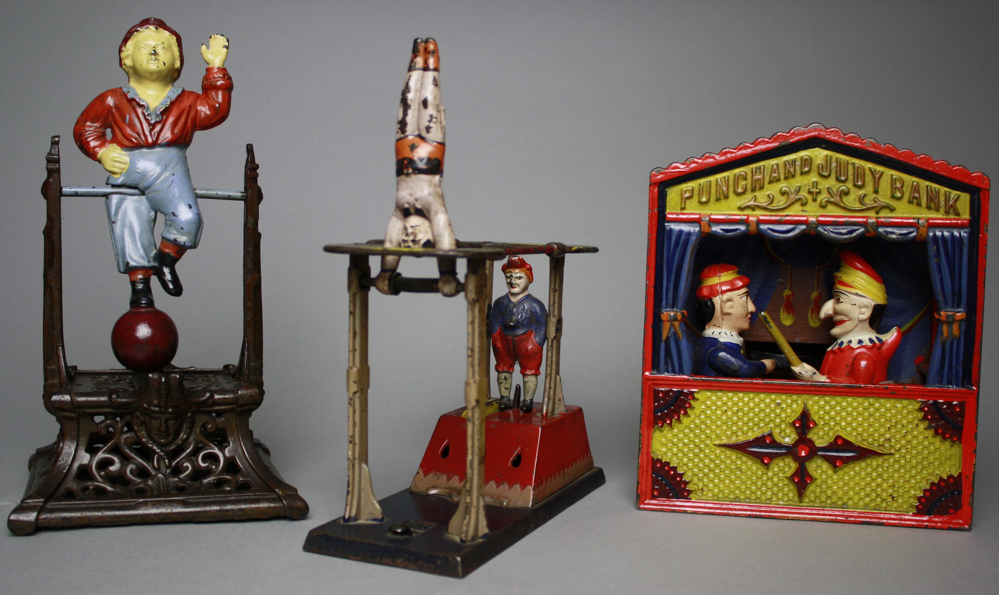 Among the many near-mint mechanical banks to be auctioned are (left to right): Boy on Trapeze, Acrobats, and Punch and Judy with large-size lettering. RSL Auction image