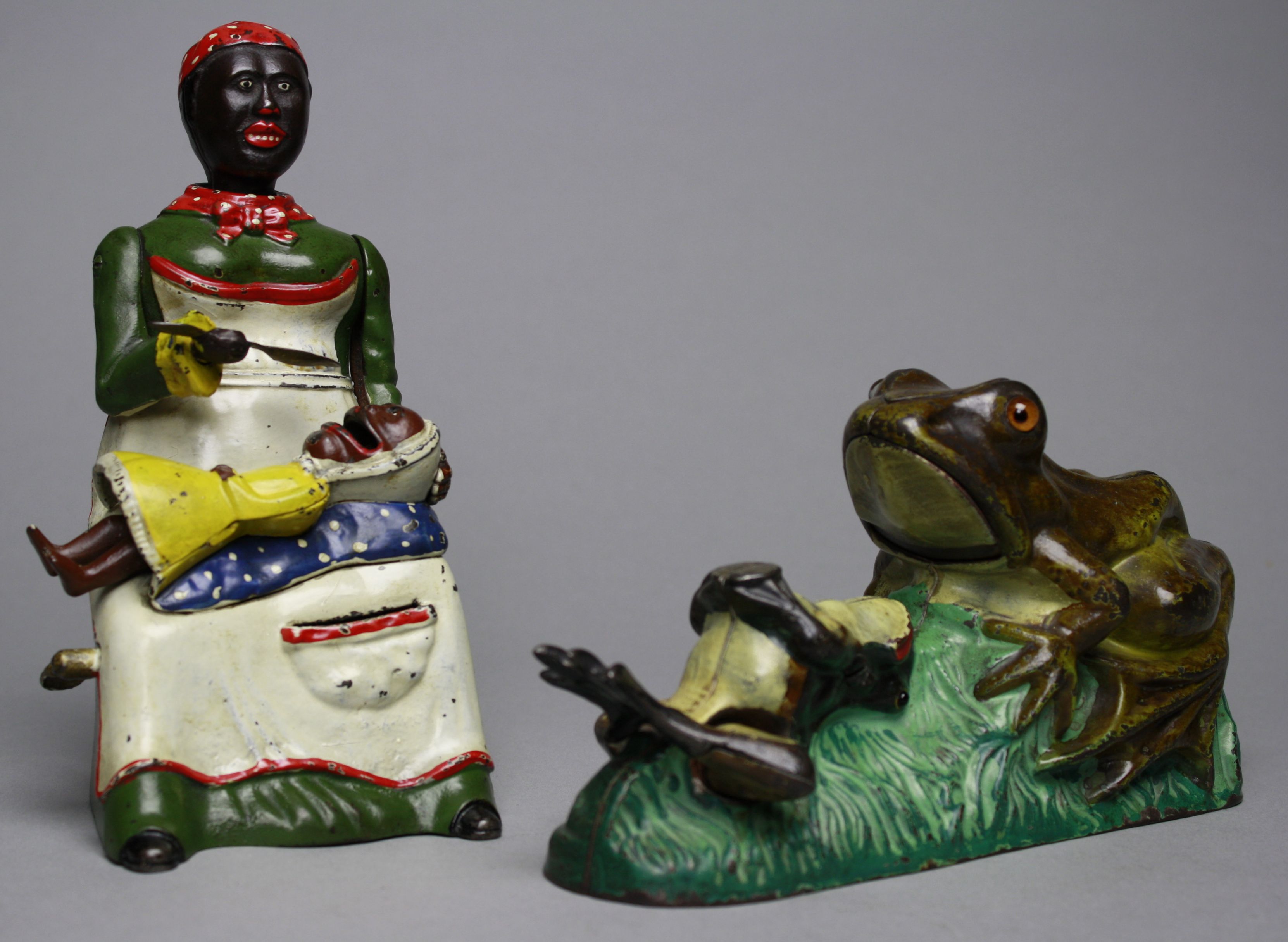 Finest known example of a green-dress Mammy mechanical bank plus an exceptional Two Frogs mechanical bank. RSL Auction image