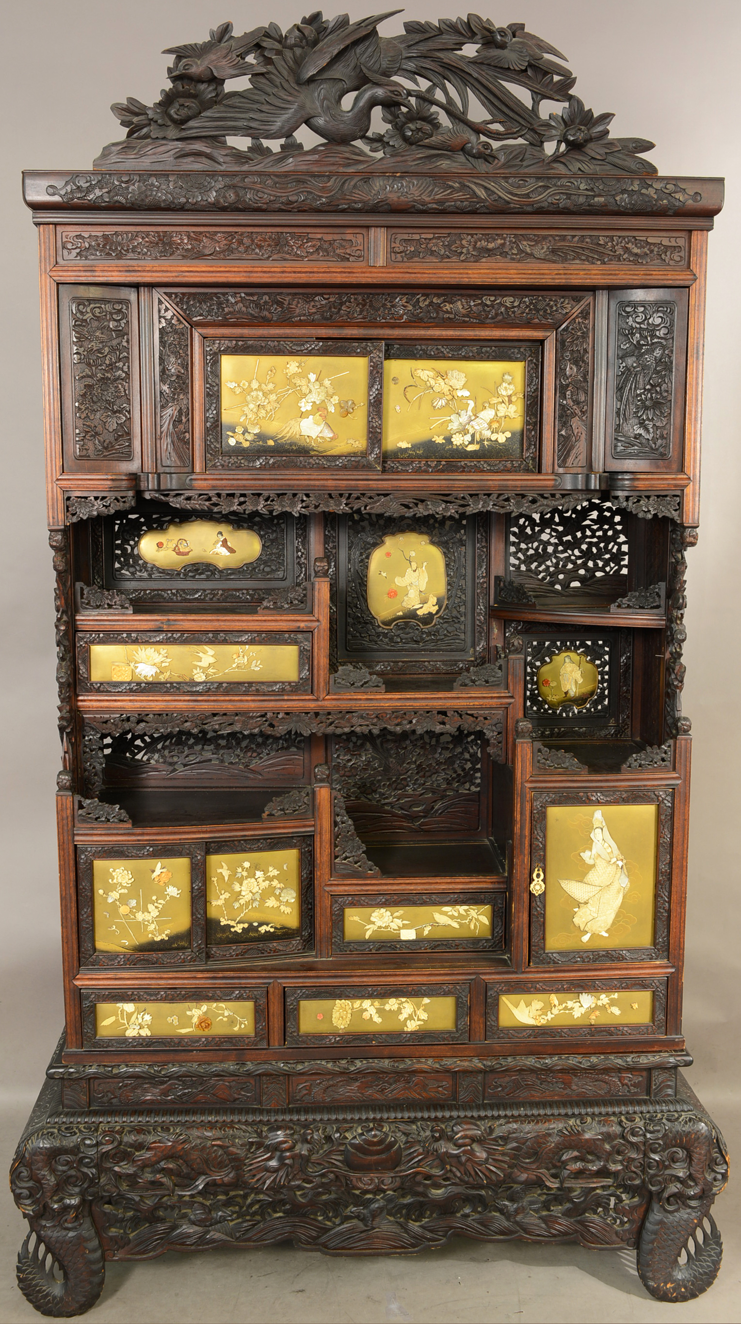 Chinese-style carved cabinet with birds and flowers carved in crest, scenic carved panels on heavily carved base, 83in high x 45in wide, circa 1910. Estimate: $1,800-$2,400. Bruhns Auction Gallery image