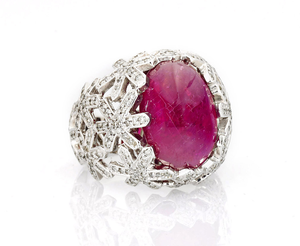 Charming 14K white gold cocktail ring centering a high-domed Burmese ruby cabochon, flanked on either side in a reticulated, diamond-set snowflake design; size 5 1/2. Estimate $2,500-$3,000. I.M. Chait image