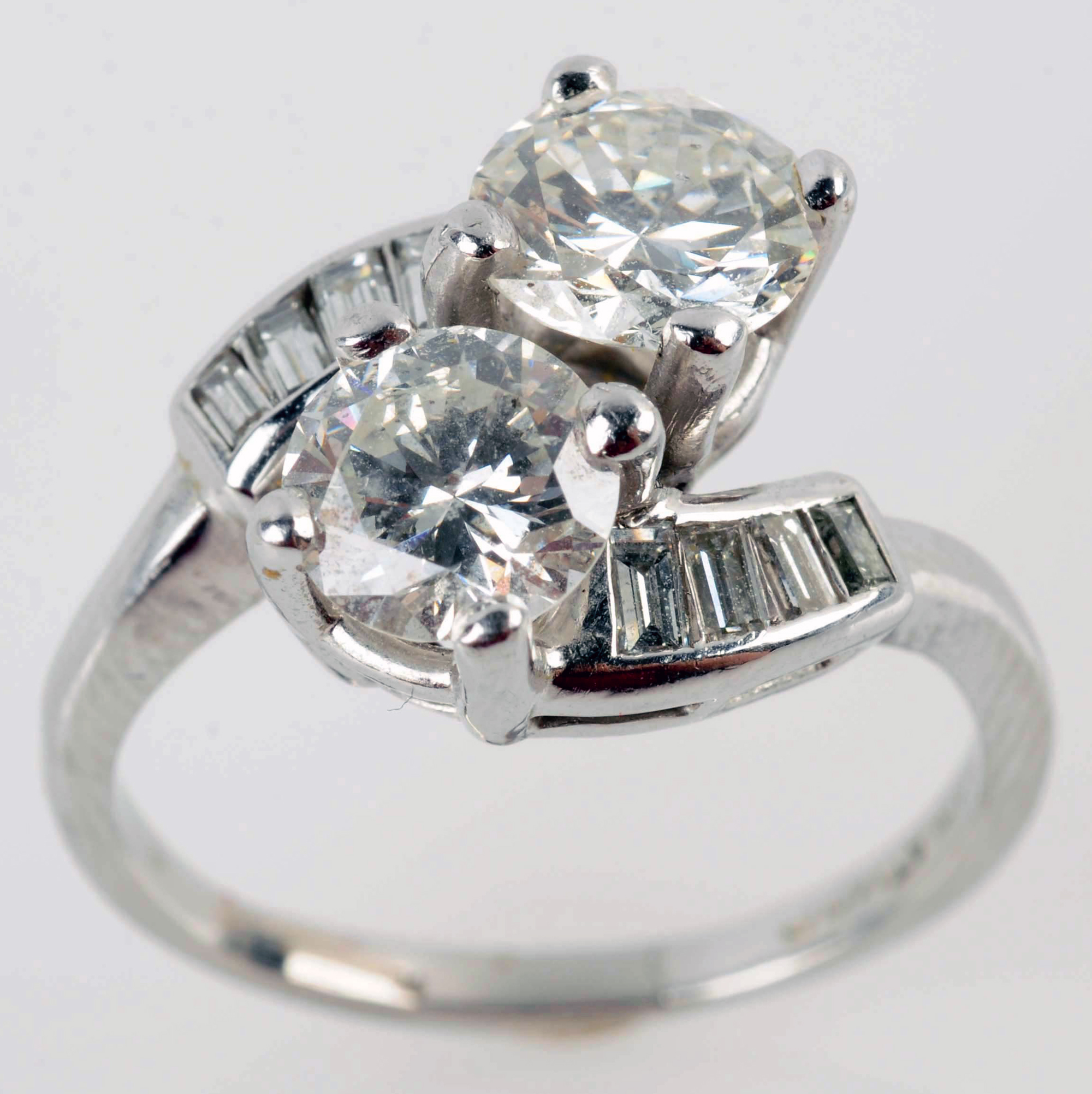 Diamond dinner ring in platinum setting, two large diamonds flanked by eight tapered, baguette-cut diamonds. Diamonds are approximately 1.00ct and 1.15ct, VS2 - SI1 clarities, L-M colors, ring size 8, 5.0 dwt. Estimate: $2,500-$4,000. Morphy Auctions image