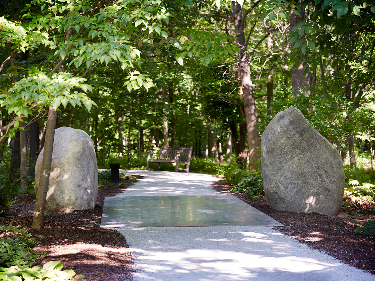 Granite boulders are the start of a minimalist and earthwork piece titled 'Relatum: Forest Path' by Lee Ufan, which is installed in the Gwen Frostic Woodland Shade Garden. Photo by Peter McDaniel, courtesy of Frederik Meijer Gardens & Sculpture Park