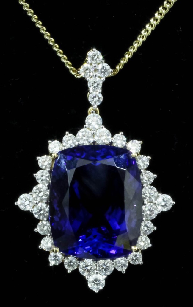 An 18K gold-mounted pendant, the oval cut tanzanite weighing approximately 29 carats, surrounded by 33 small brilliant-cut diamonds. Accompanied by a certificate confirming the tanzanite to be AAA quality, it sold for £3,600. Photo The Canterbury Auction Galleries