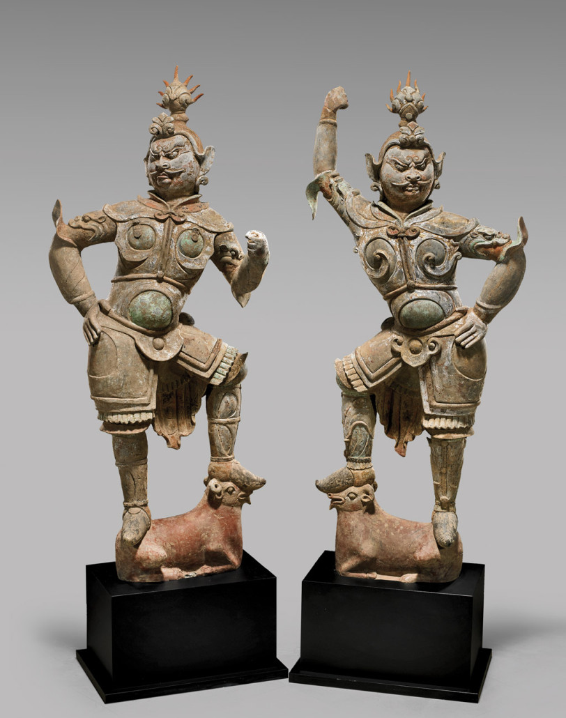 Pair of Tang Dynasty painted pottery Lokapala standing atop rams surmounted on pedestals, each figure 52½ inches tall. Est. $60,000-$80,000 (pair)