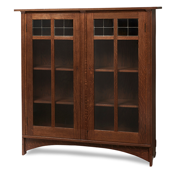 Gustav Stickley, designed by Harvey Ellis (1852-1904) bookcase, no. 703, Eastwood, N.Y, oak, signed with paper label and red decal, 54 inches wide x 14 inches deep x 58 inches. Treadway Toomey Auctions image
