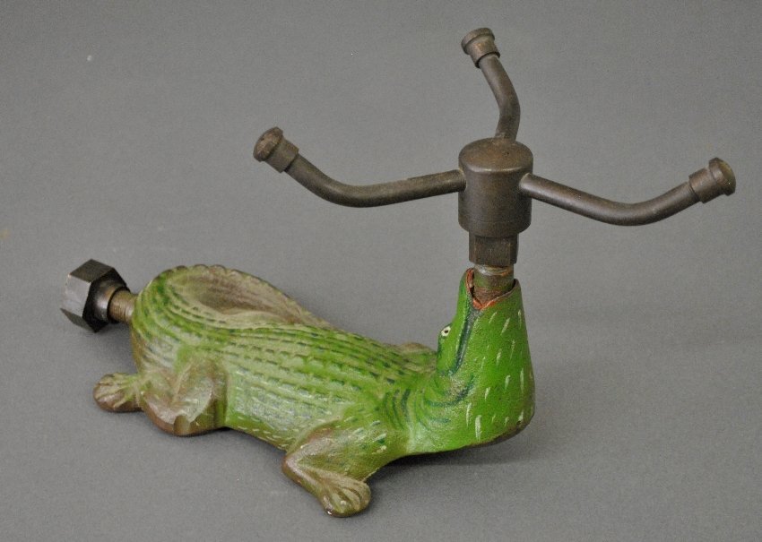 Cast iron alligator lawn sprinkler with original paint and brass rotating sprinkler head. Sold for $300