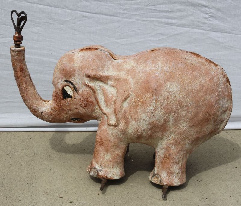 Art Deco period cast iron full bodied elephant form lawn sprinkler in old pink & white & rust surface. Sold for $1,800