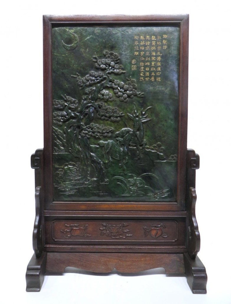 Large Chinese hand-carved spinach green jade table screen, with carvings that depict deer and a pine tree under a sliver of a moon on the front. Estimate: $3,000-$5,000. Converse Auctions image