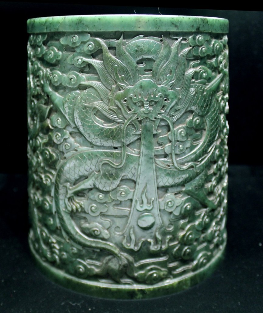 Chinese spinach green jade brushpot, 6 1/2 inches tall. The body is cylindrical and straight. The exterior depicts a pair of dragons. Estimate: $3,000-$5,000. Converse Auctions image