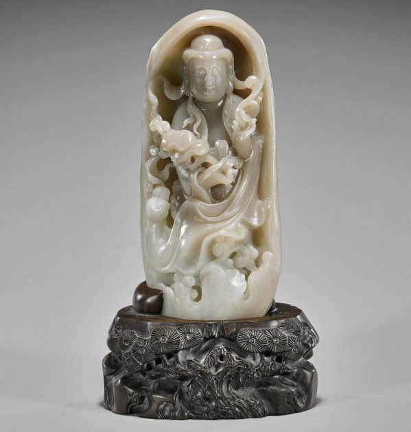 Chinese carved jade figure of Guanyin holding an elaborate ruyi scepter and standing within a boulder-form border, 11 3/4 inches high. Estimate: $2,500-$3,500. I.M. Chait Gallery/Auctioneers image