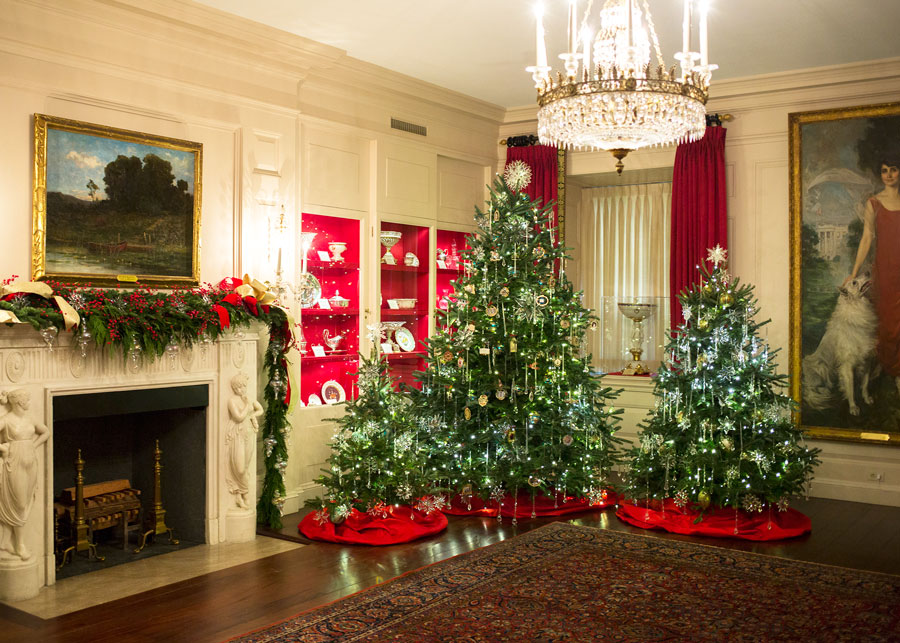 Decorated Christmas trees in the White House 'China Room,' referring to the Presidential china collection displayed in wall cases. White House photo