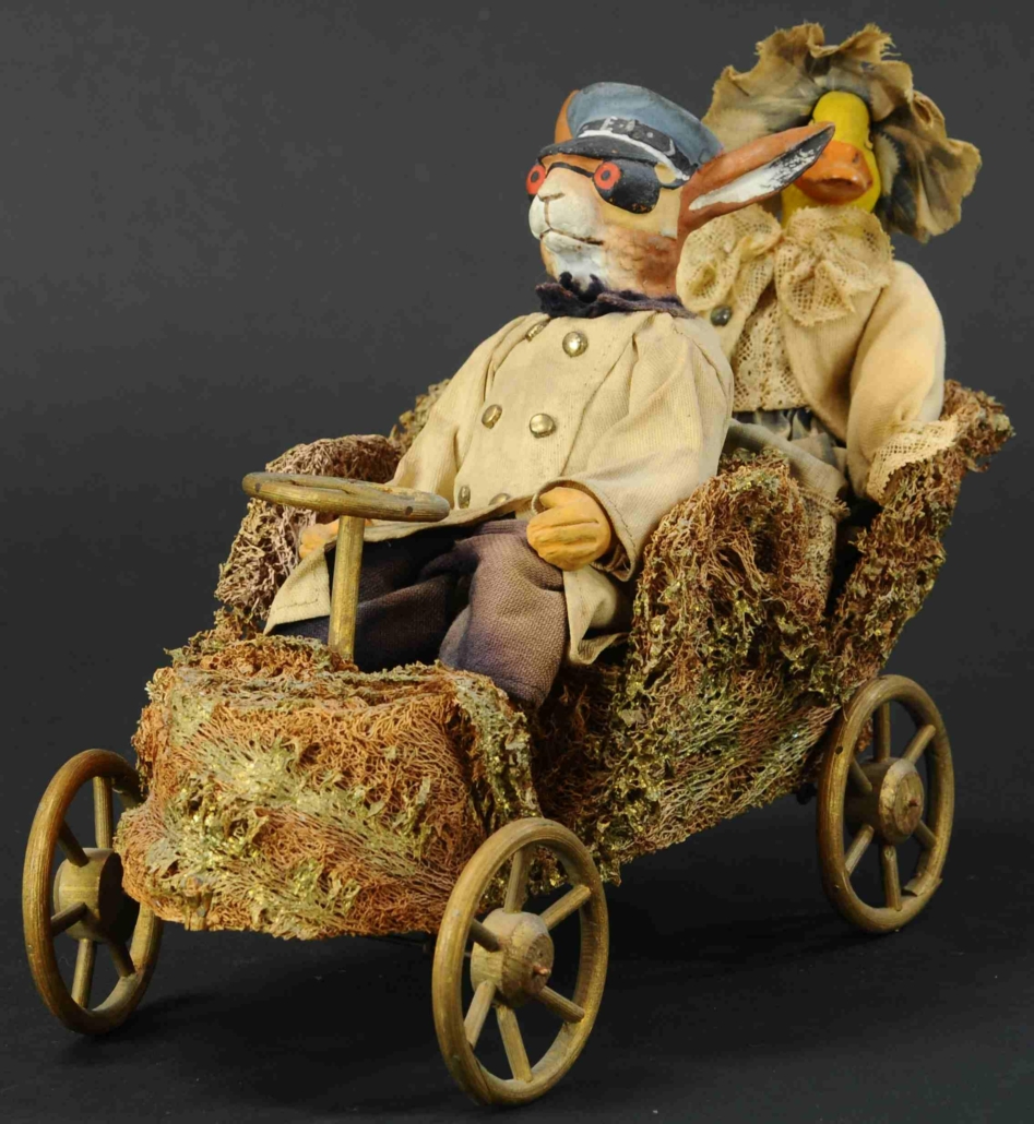 This moss automotive candy container driven by a rabbit chauffeur and a duck passenger, both composition figures, is the kind of unusual example that serious collectors look for.