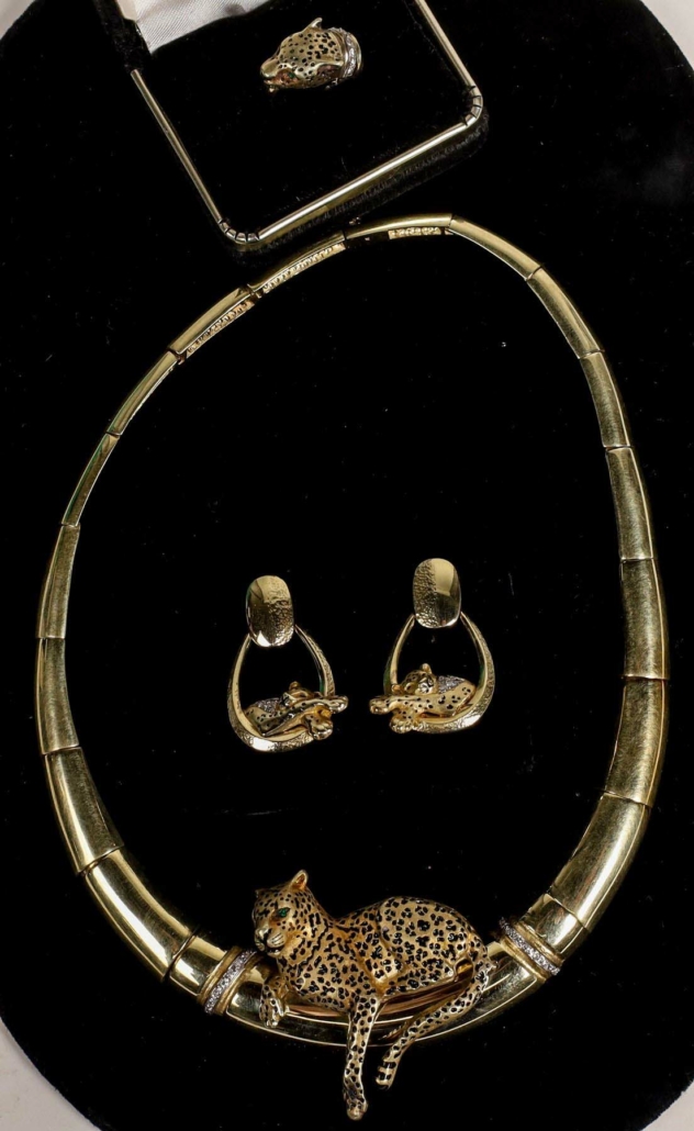 Custom leopard-themed jewelry set containing a necklace with diamond bands and emerald eyes, gold and diamond earrings, and a ring, estimated at $10,000-$15,000