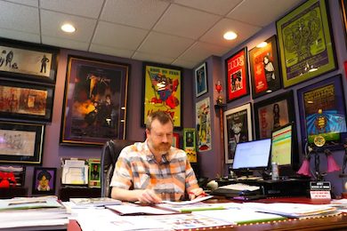 Alex Winter working in his office at Hake’s, surrounded by some of his collections, including records.