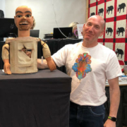 Steve Slotin poses with a ventriloquist’s dummy that was being auctioned by Slotin Folk Art Auction. His wife Amy joked that it looked like Steve’s twin, prompting his bemused expression.