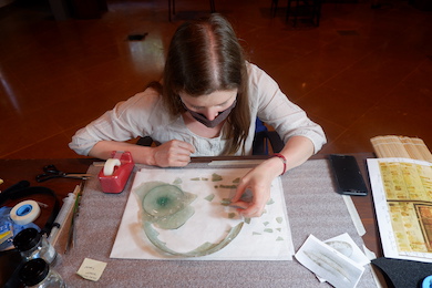 Conservator Claire Cuyaubere assisting with "puzzle-work" on a shard from a glass dish at the Archaeological Museum, AUB. Courtesy of the AUB Office of Communications and Archaeological Museum