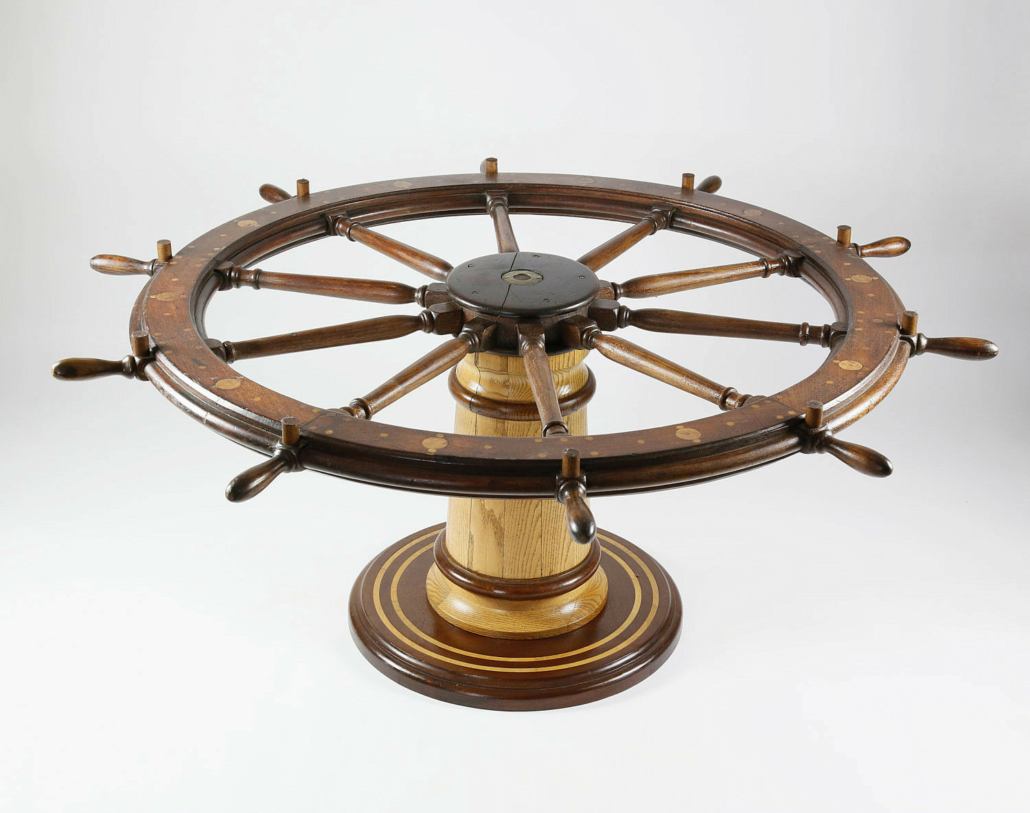 Glass-topped inlaid ship’s wheel table, estimated at $4,000-$6,000