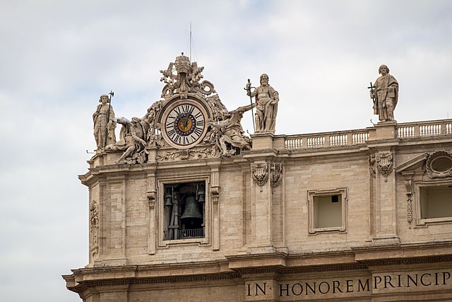 A detail shot of the clock and bell of St. Peter’s Basilica at the Vatican, taken in 2013. The Vatican recently opened an exhibition space for contemporary art in its Apostolic Library. The inaugural show, Tutti, closes February 22, 2022. Image courtesy of Wikimedia Commons, photo credit Dietmar Rabich. Licensed under the Creative Commons Attribution ShareAlike 4.0 International license.